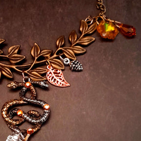 swarovski crystal necklace with large yellow icicle crystal and flower crystals in green and orange. Autumn necklace with nature motifs pinecone leaves and 2 intertwined snakes