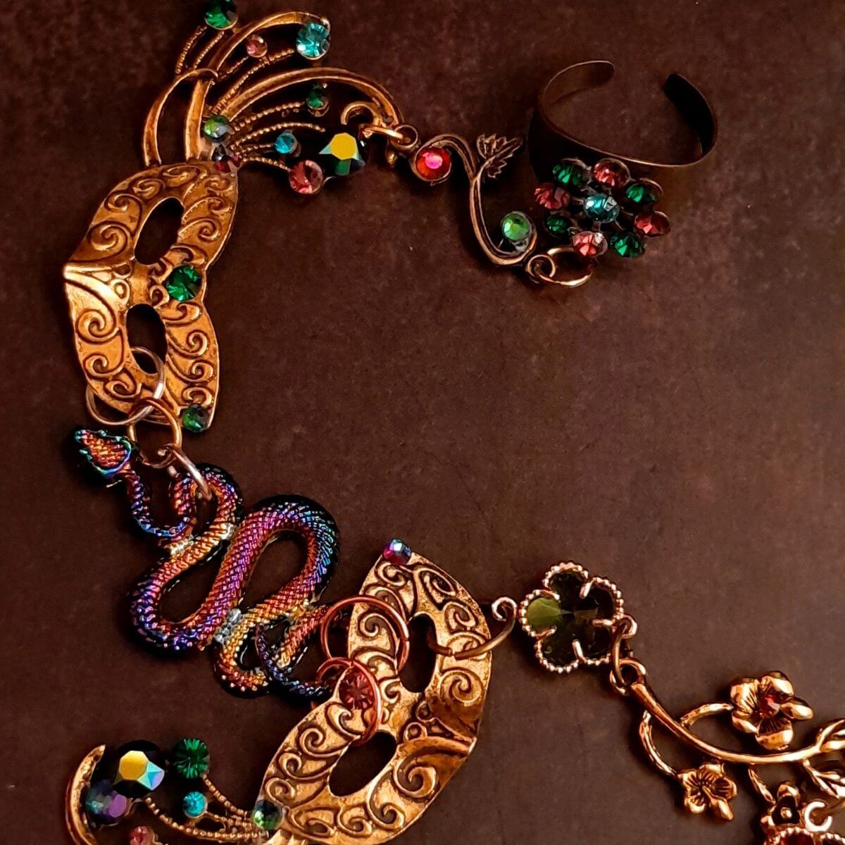 slave bracelet hand chain with adjustable flower ring and masks. colcorful flowers and vines a serpent snake and swarovski crystals