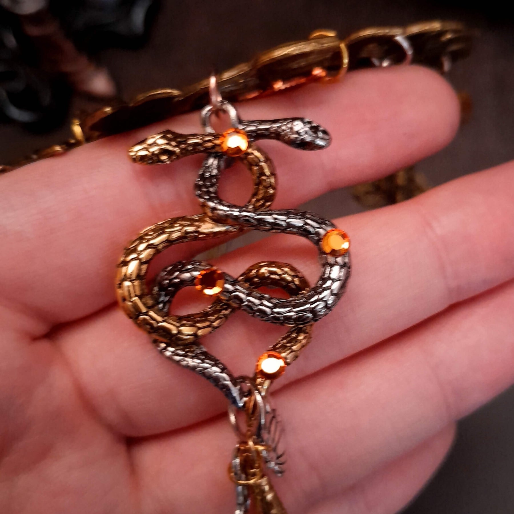 swarovski crystal necklace with large yellow icicle crystal and flower crystals in green and orange. Autumn necklace with nature motifs pinecone leaves and 2 intertwined snakes