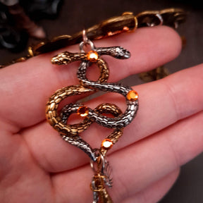 swarovski crystal necklace with large yellow icicle crystal and flower crystals in green and orange. Autumn necklace with nature motifs pinecone leaves and 2 intertwined snakes