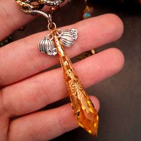 swarovski crystal necklace with large yellow icicle crystal and flower crystals in green and orange. Autumn necklace with nature motifs pinecone leaves and 2 intertwined snakes