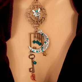 Victorian style bird necklace with tree of life cabochon, bird cage and bird, turquoise swarovski crystals silver filigree moon gold star and copper leaf. 