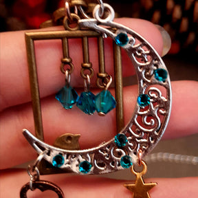 Victorian style bird necklace with tree of life cabochon, bird cage and bird, turquoise swarovski crystals silver filigree moon gold star and copper leaf. 