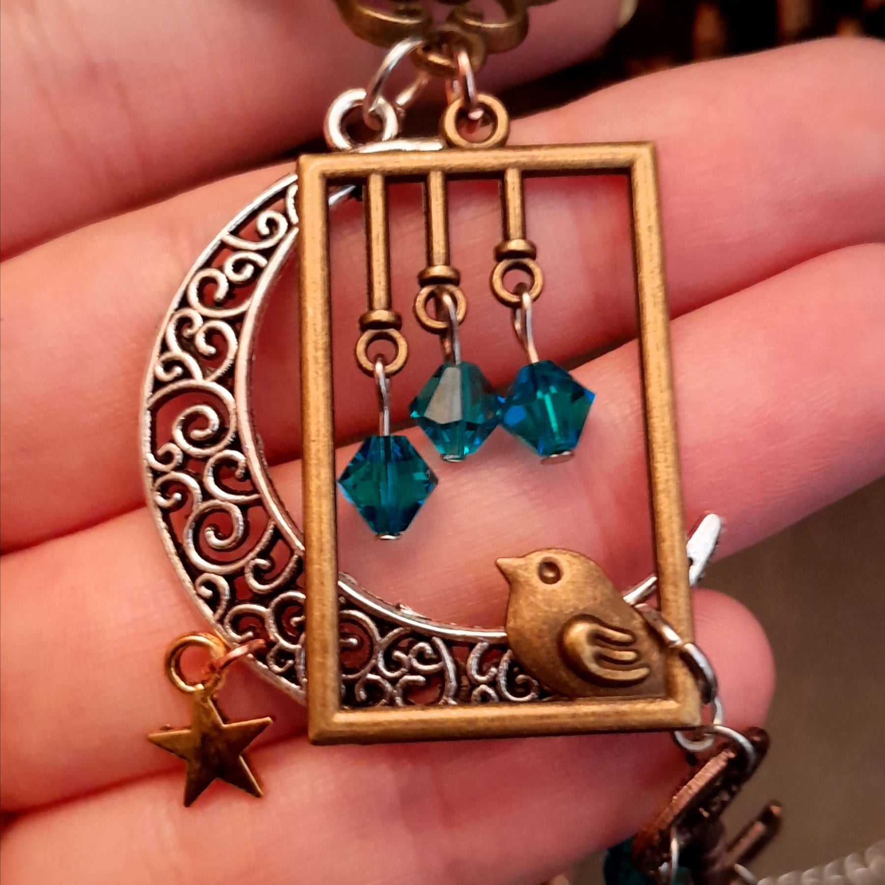 Victorian style bird necklace with tree of life cabochon, bird cage and bird, turquoise swarovski crystals silver filigree moon gold star and copper leaf. 