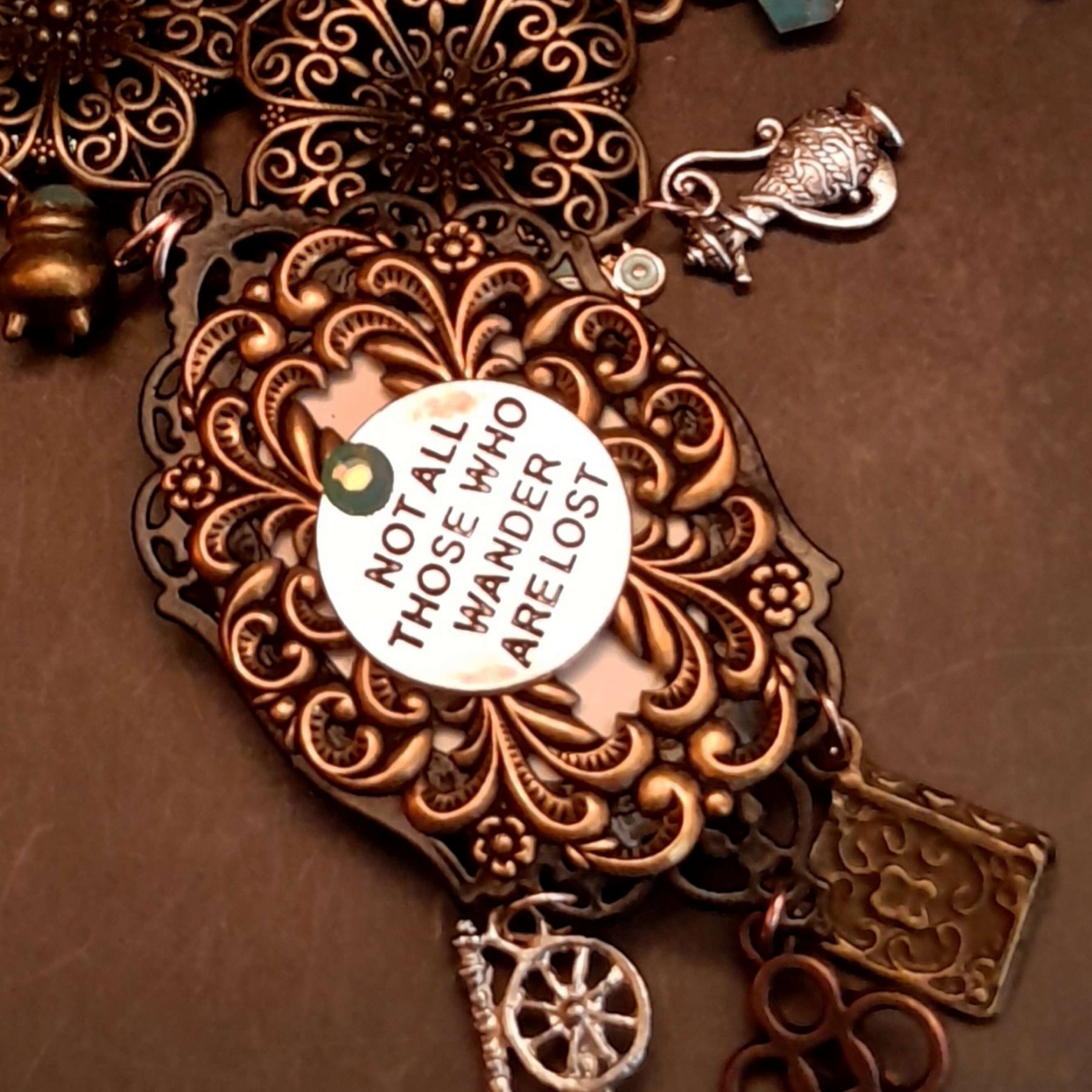 Flat lay of witchy black crow fairy tale necklace with charms and Swarovski crystals, Victorian style vintage style handmade jewelry, Rachel Flam Design