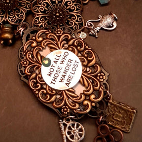 Flat lay of witchy black crow fairy tale necklace with charms and Swarovski crystals, Victorian style vintage style handmade jewelry, Rachel Flam Design