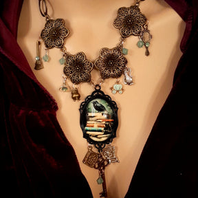 Full view of witchy black crow necklace with storybook charms and Swarovski crystals, Victorian style vintage style handmade jewelry, Rachel Flam Design