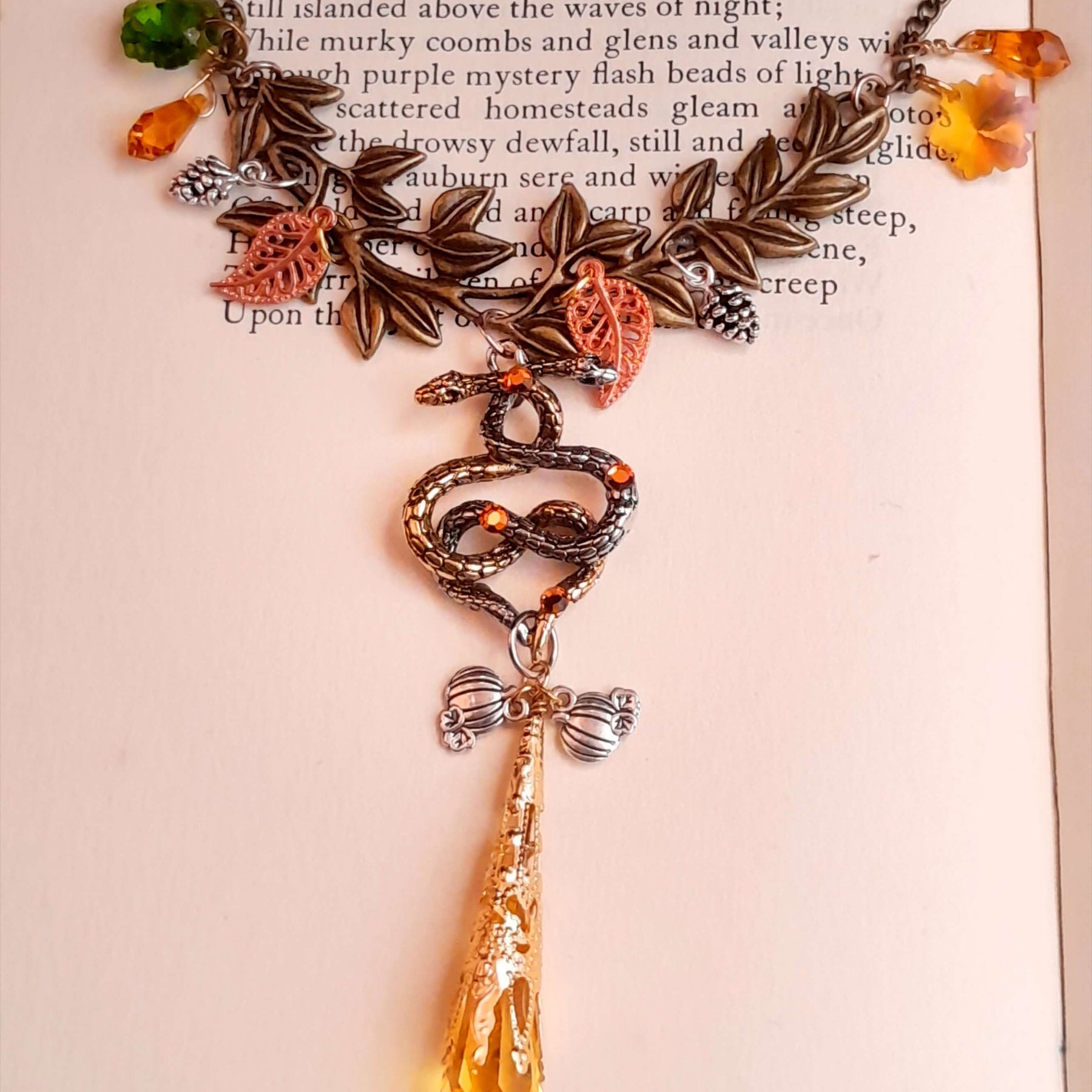 swarovski crystal necklace with large yellow icicle crystal and flower crystals in green and orange. Autumn necklace with nature motifs pinecone leaves and 2 intertwined snakes