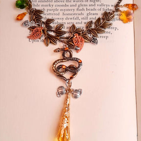 swarovski crystal necklace with large yellow icicle crystal and flower crystals in green and orange. Autumn necklace with nature motifs pinecone leaves and 2 intertwined snakes